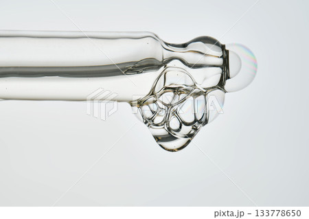 Cosmetic pipette dispensing serum with bubbles macro 133778650