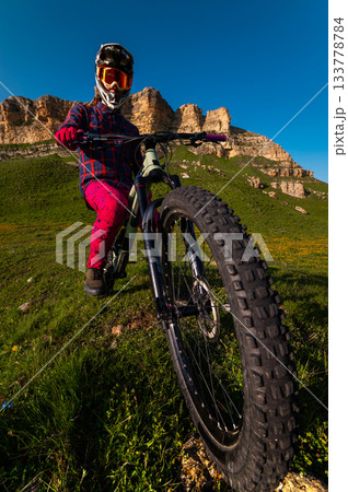 Nature and mountain biking, morning training and extreme sports on the trail. A man cycling outdoors against a backdrop of rocky mountains Nature and mountain biking, morning training and extreme sports on the trail. A man cycling outdoors against a backdrop of rocky mountains 133778784