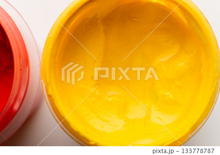 close-up shot of thick, bright yellow paint in a plastic jar. Gouache paint set. Jars of gouache are painted on a white background close-up shot of thick, bright yellow paint in a plastic jar. Gouache paint set. Jars of gouache are painted on a white background 133778787