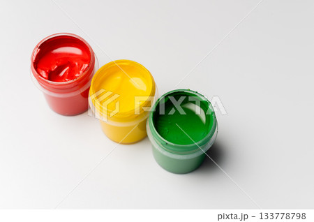 Artist's gouache, top view from the side. Three open bottles of gouache for painting on a pure white background. New paints for painting 133778798