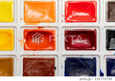 Close-up of a palette with multi-colored paints in a box, new but already used, open paints for creativity 133778799