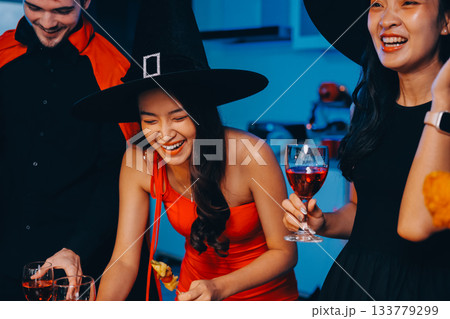 Joyful office Halloween party with coworkers in costumes, celebrating with drinks and laughter, fostering teamwork and festive spirit Joyful office Halloween party with coworkers in costumes, celebrating with drinks and laughter, fostering teamwork and festive spirit 133779299
