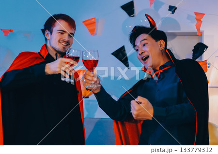 Joyful office Halloween party with coworkers in costumes, celebrating with drinks and laughter, fostering teamwork and festive spirit 133779312