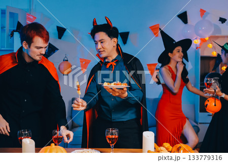 Joyful office Halloween party with coworkers in costumes, celebrating with drinks and laughter, fostering teamwork and festive spirit 133779316
