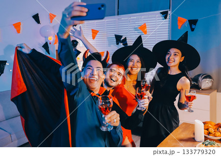 Joyful office Halloween party with coworkers in costumes, celebrating with drinks and laughter, fostering teamwork and festive spirit 133779320
