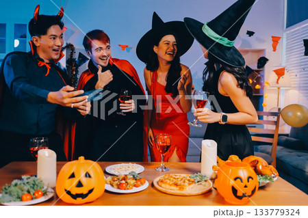 Joyful office Halloween party with coworkers in costumes, celebrating with drinks and laughter, fostering teamwork and festive spirit 133779324
