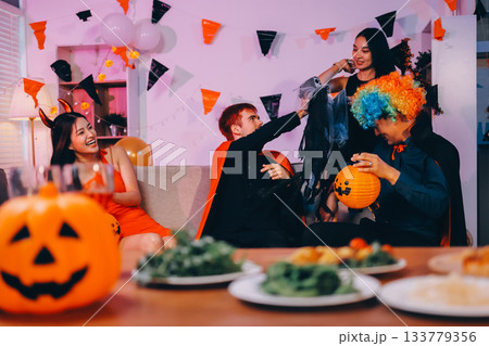 Joyful office Halloween party with coworkers in costumes, celebrating with drinks and laughter, fostering teamwork and festive spirit Joyful office Halloween party with coworkers in costumes, celebrating with drinks and laughter, fostering teamwork and festive spirit 133779356