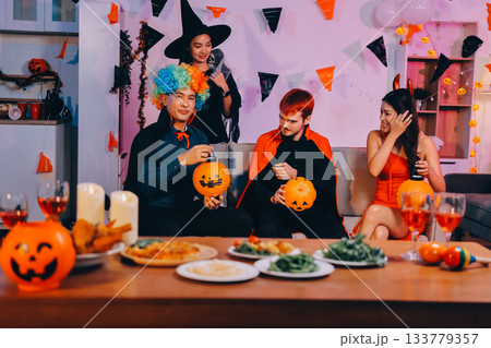 Joyful office Halloween party with coworkers in costumes, celebrating with drinks and laughter, fostering teamwork and festive spirit 133779357
