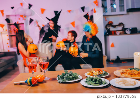 Joyful office Halloween party with coworkers in costumes, celebrating with drinks and laughter, fostering teamwork and festive spirit Joyful office Halloween party with coworkers in costumes, celebrating with drinks and laughter, fostering teamwork and festive spirit 133779358
