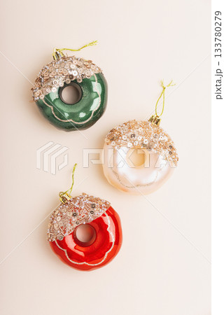 Christmas Donuts Ornaments and Pine Branches on Light Beige Background Christmas Donuts Ornaments and Pine Branches on Light Beige Background 133780279