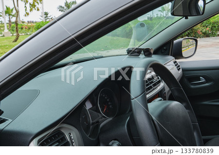 Sunglasses sitting on car dashboard driving on road trip Sunglasses sitting on car dashboard driving on road trip 133780839