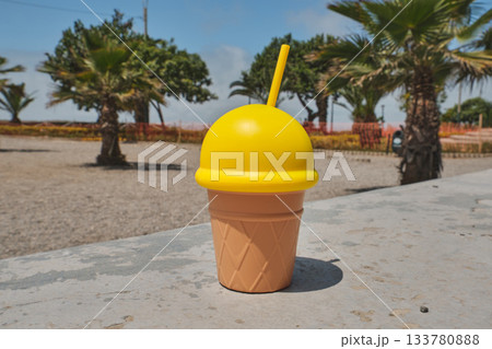 Yellow ice cream cup with straw on a summer day Yellow ice cream cup with straw on a summer day 133780888