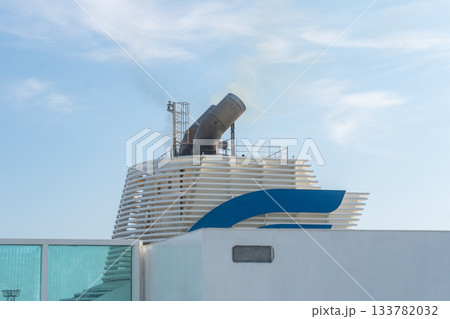 View of a ferrys funnel rising above the upper deck against a bright sky. The clean lines and soft lighting highlight maritime engineering details and the calm atmosphere of sea travel View of a ferrys funnel rising above the upper deck against a bright sky. The clean lines and soft lighting highlight maritime engineering details and the calm atmosphere of sea travel 133782032