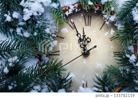 Vintage clock and fir tree branches in the snow. Vintage clock and fir tree branches in the snow. 133782119