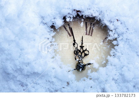 A clock with Roman numerals in the snow. A clock with Roman numerals in the snow. 133782173
