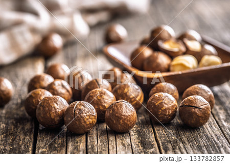Tasty macadamia nuts on wooden table. 133782857