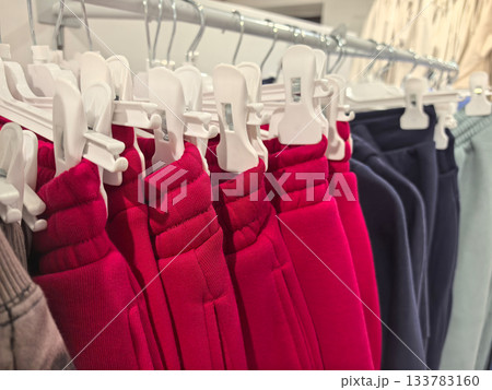 Colorful collection of clothing hanging in a stylish retail shop display 133783160