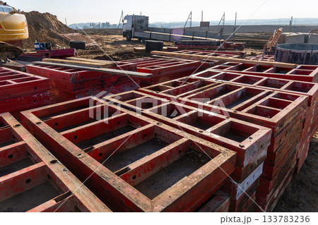 Stacked red steel formwork panels for concrete lie ready 133783236