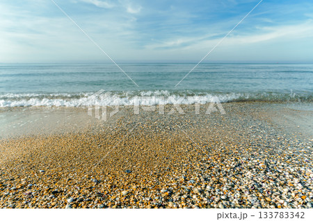 shell beach and gentle surf on a clear, warm autumn day, beach walks and relaxation on a weekend 133783342