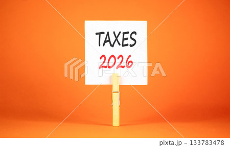 Taxes 2026 new year symbol. Concept words Taxes 2026 on beautiful white paper on wooden clothespin. Beautiful orange background. Business and taxes 2026 new year concept. Copy space. Taxes 2026 new year symbol. Concept words Taxes 2026 on beautiful white paper on wooden clothespin. Beautiful orange background. Business and taxes 2026 new year concept. Copy space. 133783478