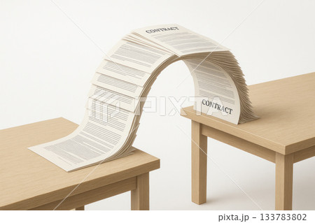 A bridge made of paper contracts connecting two wooden tables. 133783802