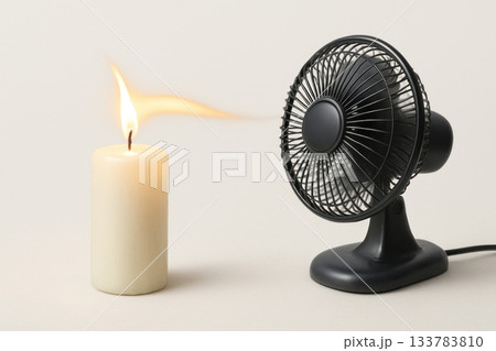 A candle flame deflected by the air flow from a table fan. A candle flame deflected by the air flow from a table fan. 133783810