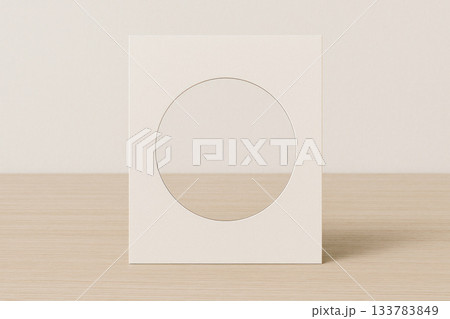 Cardboard frame with a round cutout on the table. Space for text. 133783849