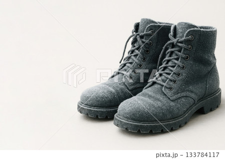 Boots covered with frost on a light background. Space for text. 133784117
