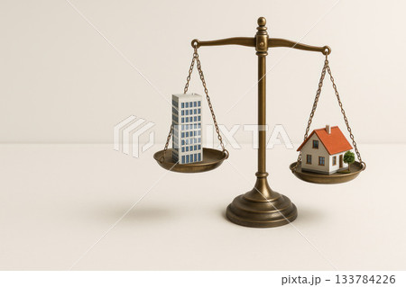 Scales with office building model and small house. Space for text. 133784226