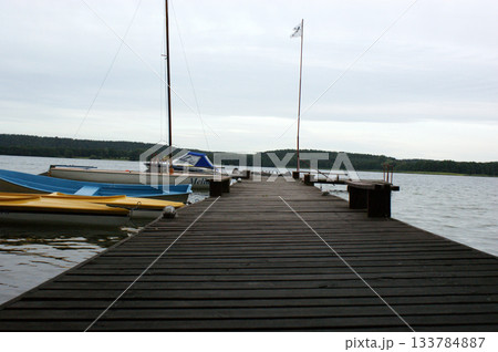 wooden bridge on the lake moored boats 133784887