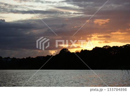 Niegocin lake Mazury Poland sunset on the lake with orange sky cloudy clouds red and purple sun 133784898