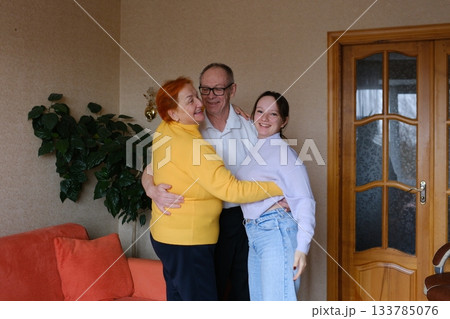 Grandparents hug their teenage granddaughter. Family values, love, home, relationships, happy family. Grandparents hug their teenage granddaughter. Family values, love, home, relationships, happy family. 133785076