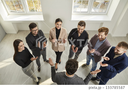 Group of joyful business people together clapping hands to congratulate their male boss. 133785587