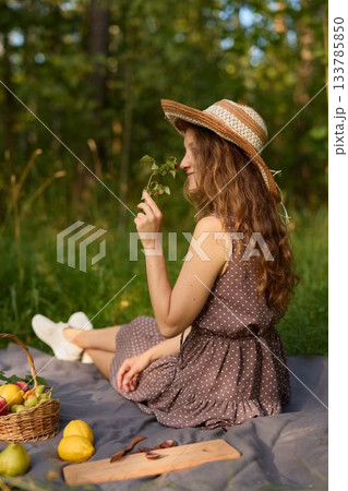 Cheerful young woman enjoys sunshine holding fruit outside Cheerful young woman enjoys sunshine holding fruit outside 133785850