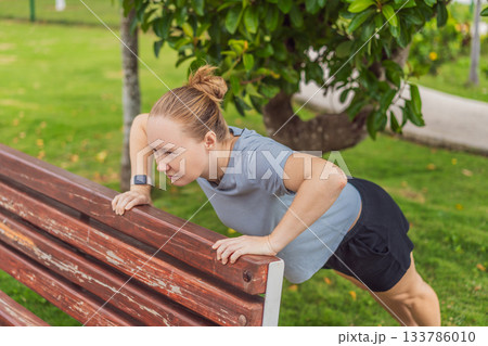Unaltered woman exercising in a park, enjoying movement, fresh air and a healthy outdoor routine. Concept of fitness, wellbeing, positive lifestyle, energy, self-care and everyday outdoor activity in Unaltered woman exercising in a park, enjoying movement, fresh air and a healthy outdoor routine. Concept of fitness, wellbeing, positive lifestyle, energy, self-care and everyday outdoor activity in 133786010