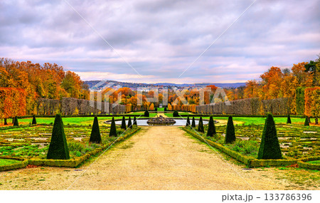 Autumn view of the formal gardens at Chateau de Champs-sur-Marne near Paris in France. Colorful fall foliage and sculpted topiaries line the path leading to a fountain Autumn view of the formal gardens at Chateau de Champs-sur-Marne near Paris in France. Colorful fall foliage and sculpted topiaries line the path leading to a fountain 133786396