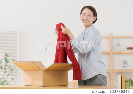 箱からセーターを出す女性 箱からセーターを出す女性 133786846