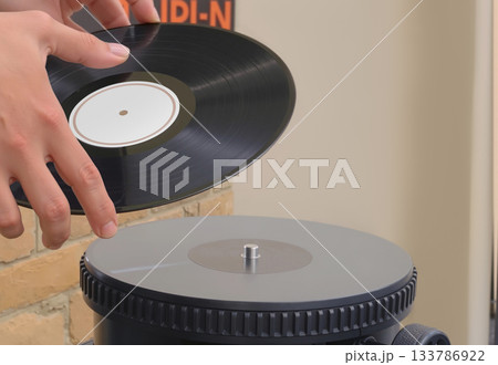 Hands holding black vinyl record over turntable, ai generated Hands holding black vinyl record over turntable, ai generated 133786922
