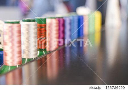 カラフルに並んだ工業用ミシン糸のスプール 133786990