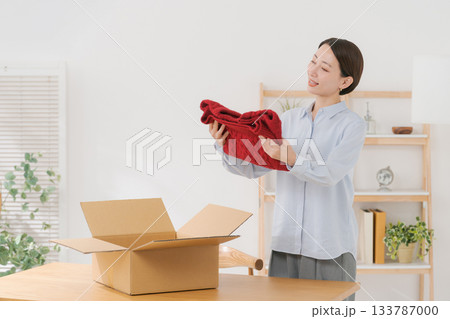 衣服を箱に梱包する女性 133787000
