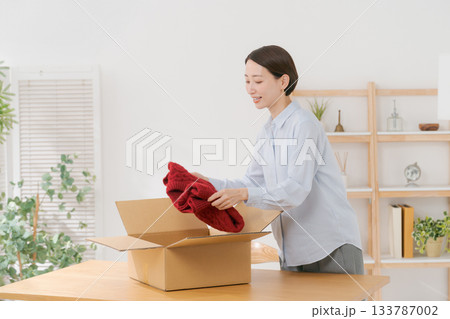 衣服を箱に梱包する女性 133787002
