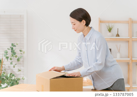 衣服を箱に梱包する女性 133787005