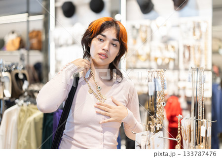 Young Asian woman chooses stylish jewelry Young Asian woman chooses stylish jewelry 133787476