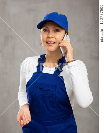 Smiling adult woman in uniform talking on phone Smiling adult woman in uniform talking on phone 133787609