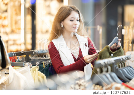 European woman choosing a warm sweater in a shopping mall European woman choosing a warm sweater in a shopping mall 133787622