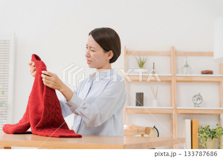 セーターを見て困る女性 133787686
