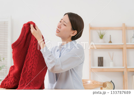 セーターを見て困る女性 133787689