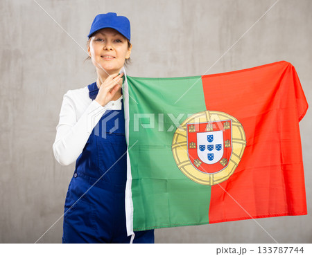 Smiling adult woman in uniform holding Portugal flag 133787744