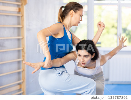 Two women training self-defense techniques in studio 133787891