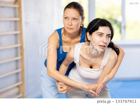 Two women training self-defense techniques in studio Two women training self-defense techniques in studio 133787911